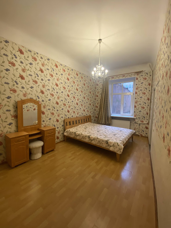 Спальня с цветочными обоями и кроватью.