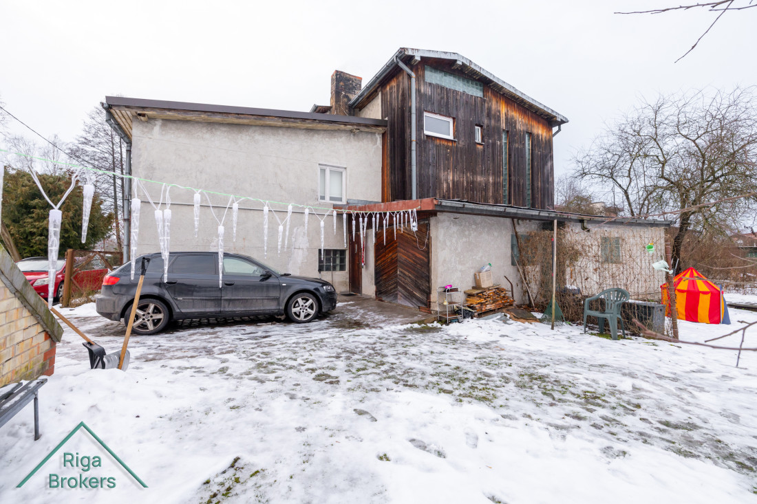 Backyard with wooden facade on house.
