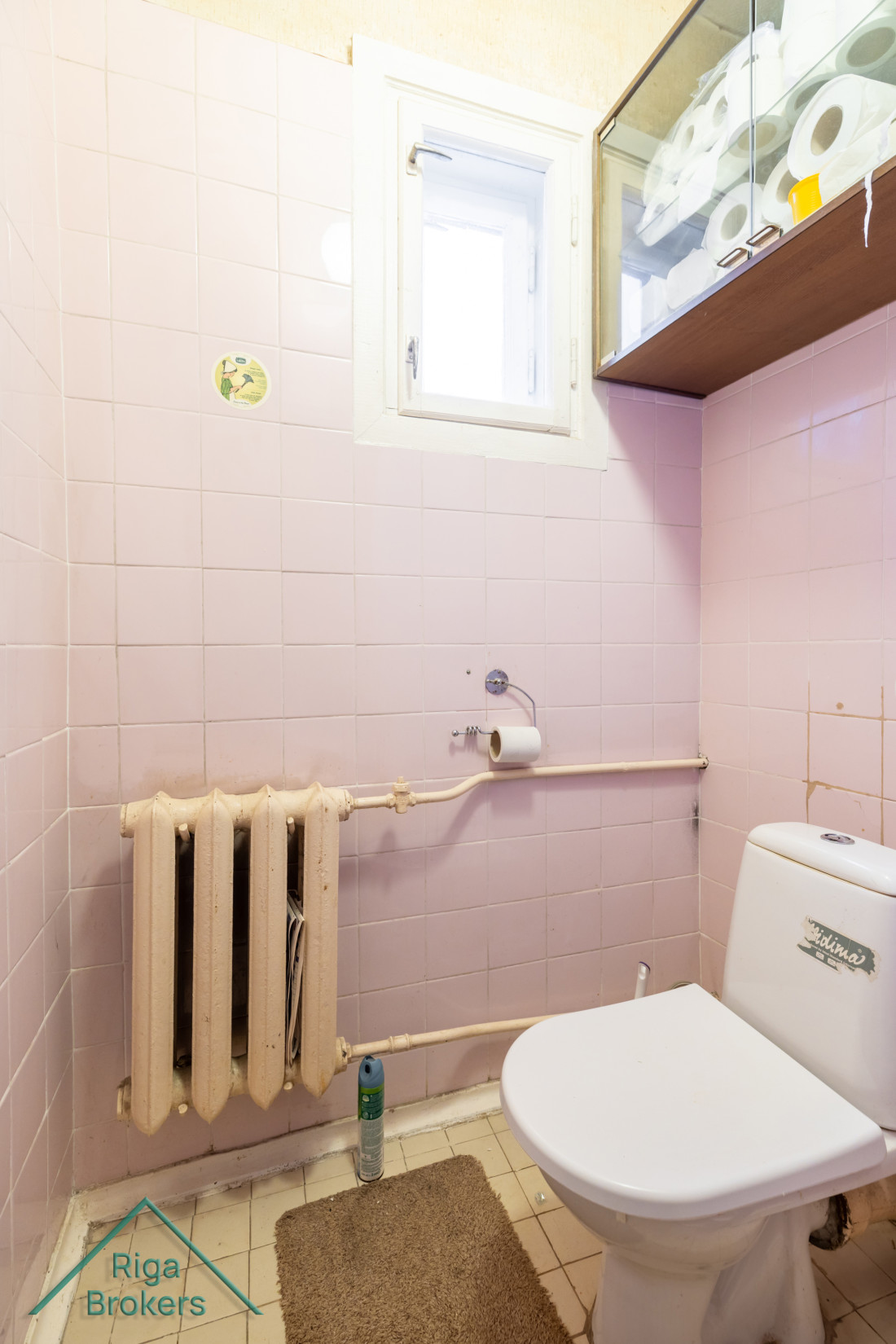 Toilet with window and radiator.