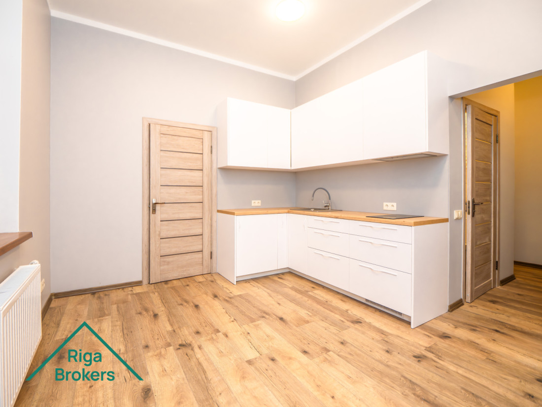 White kitchen, wooden countertop, parquet floor, minimalistic design.