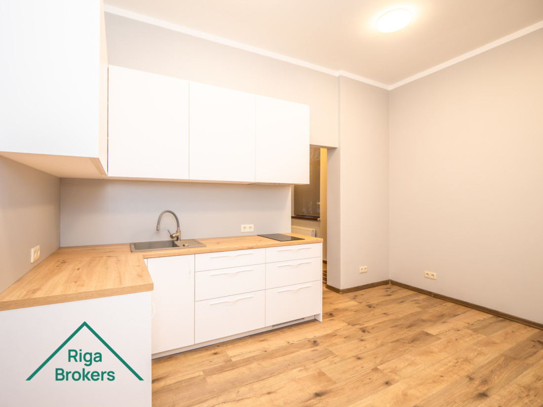 White kitchen furniture, wooden countertop, induction stove, extractor, door.