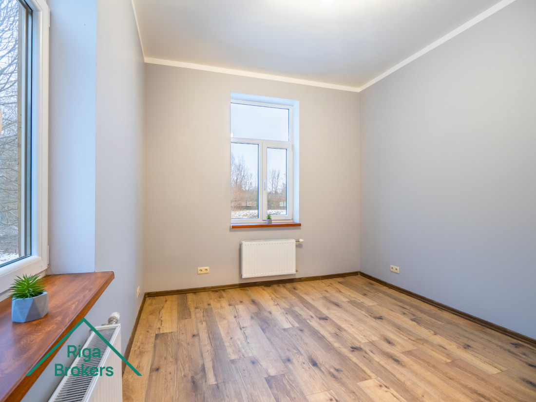 Bright room, wooden floor, large windows, modern interior.