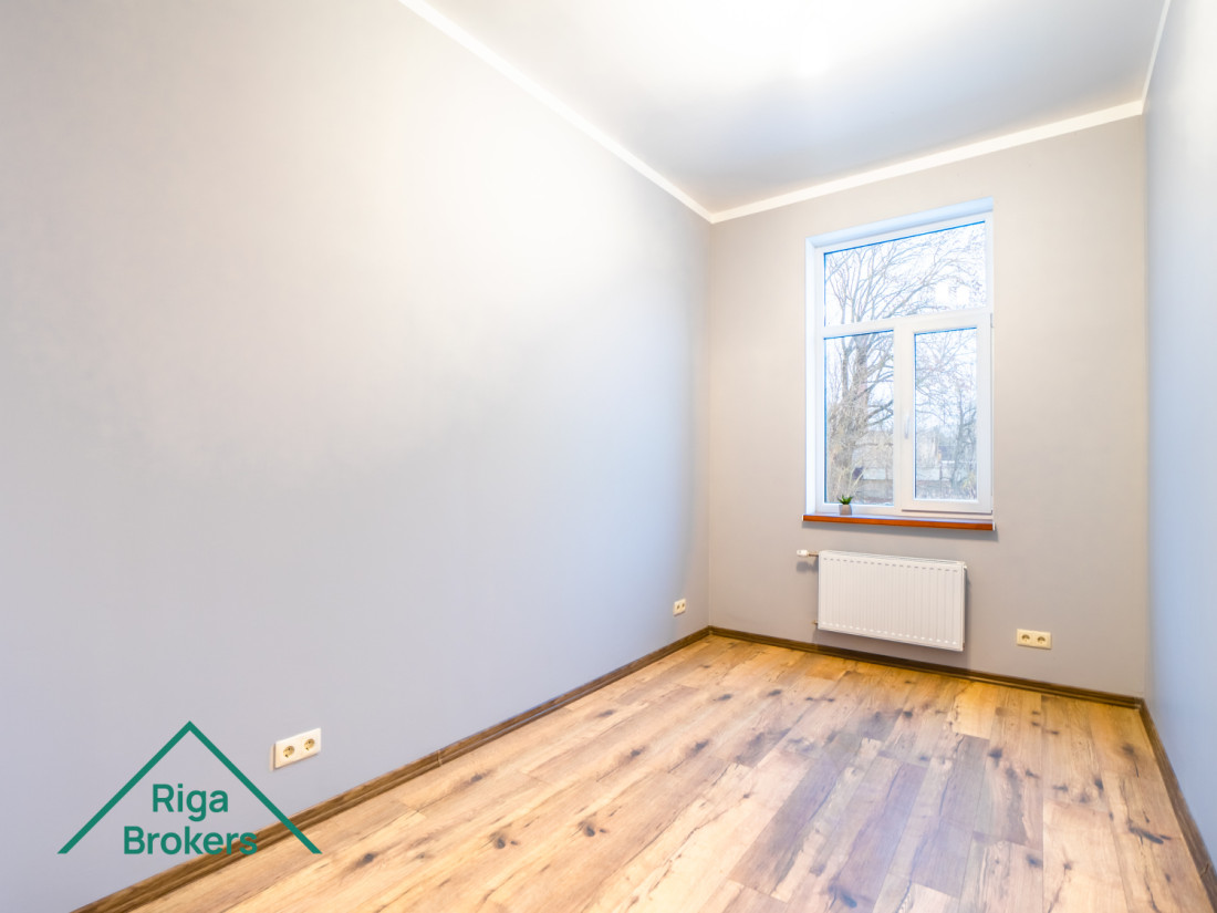  Bright room, wooden floor, large windows, modern interior.