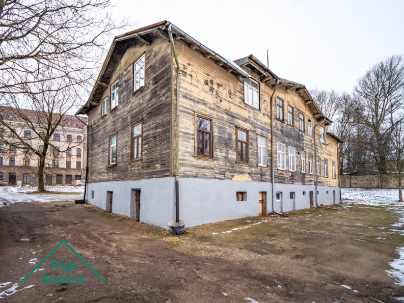 Old wooden two-story building with a red roof.