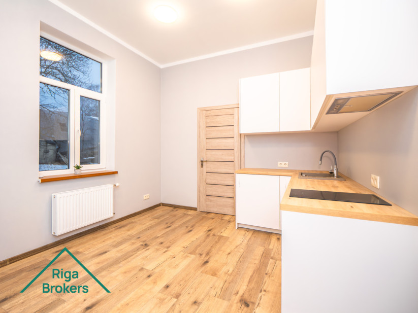 White kitchen with windows woden countertop, parquet floor, minimalistic design.