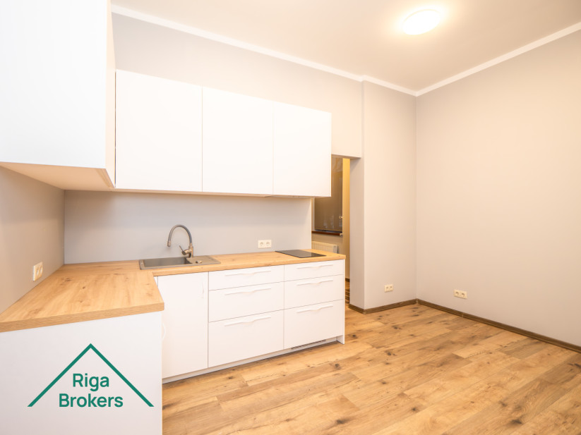White kitchen furniture, wooden countertop, induction stove, extractor, door.