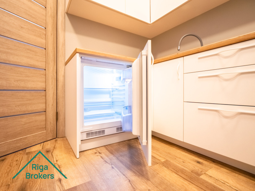 White kitchen furniture, wooden countertop, induction stove, extractor, door.