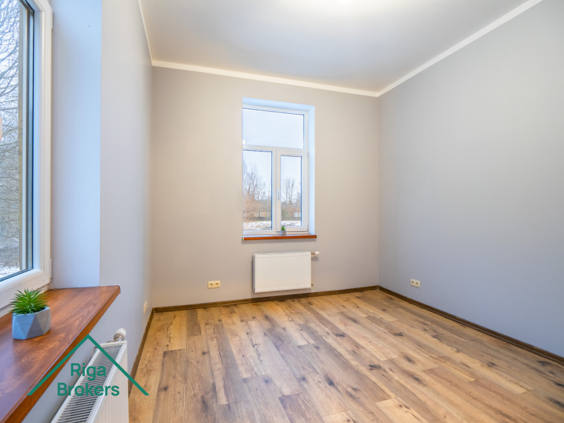 Bright room, wooden floor, large windows, modern interior.
