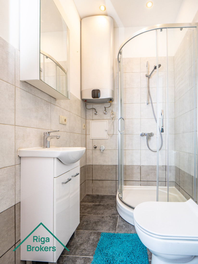 White bathtub, shower, boiler, toilet, sink.