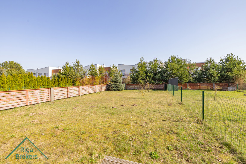 Fenced backyard with lawn and trees