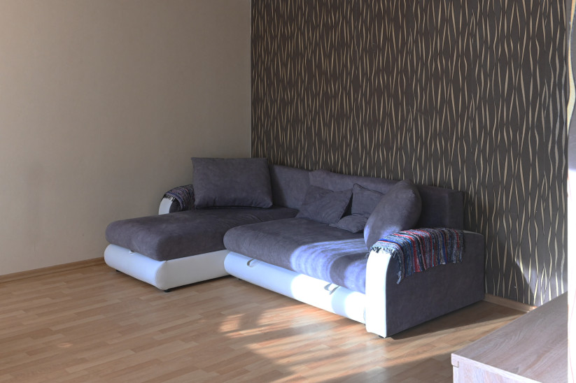 Living room with grey corner sofa and feature wall