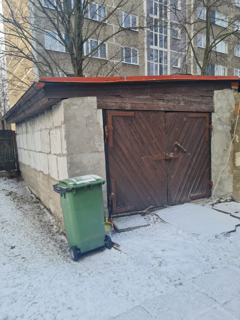 Backyard shed with green container.