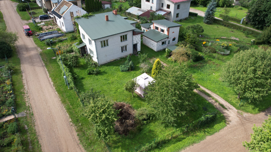 Mājas pagalms ar zaļu ainavu