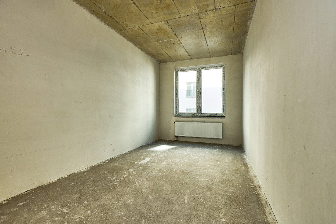 Narrow room with concrete ceiling.