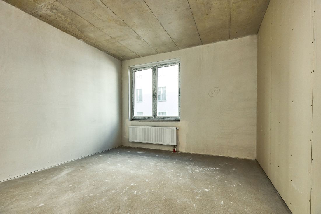 Empty room with window and radiator.