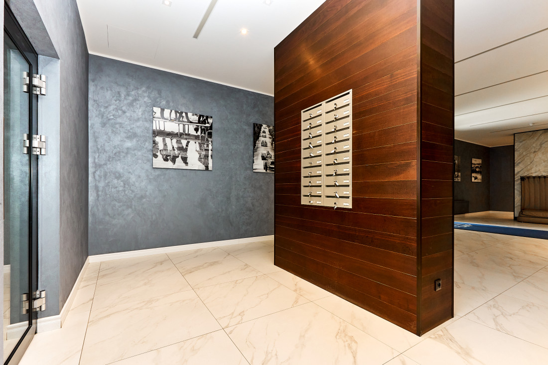 Modern mailboxes on wooden wall.