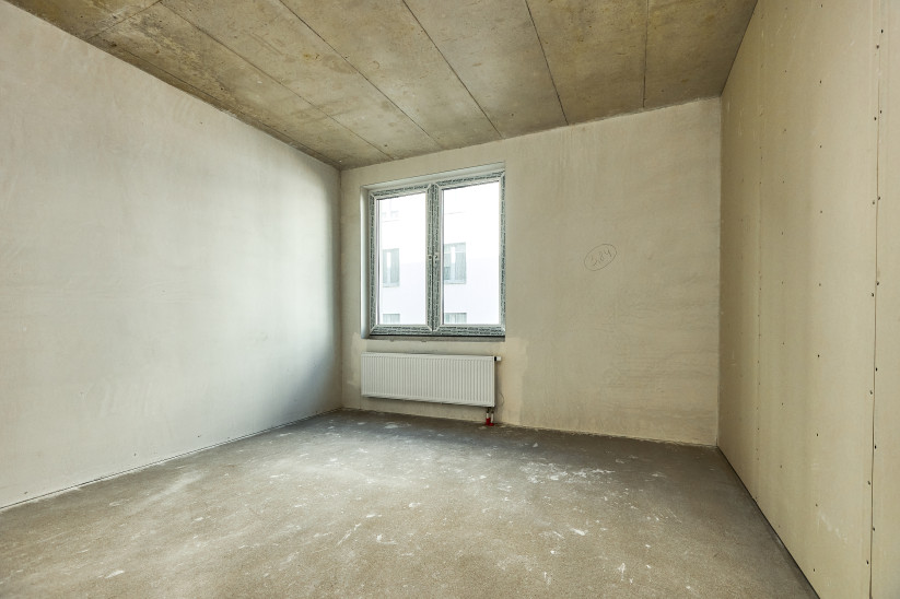 Empty room with window and radiator.