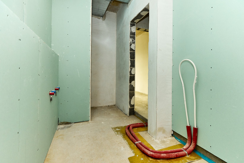 Unfinished room with green wall lining.