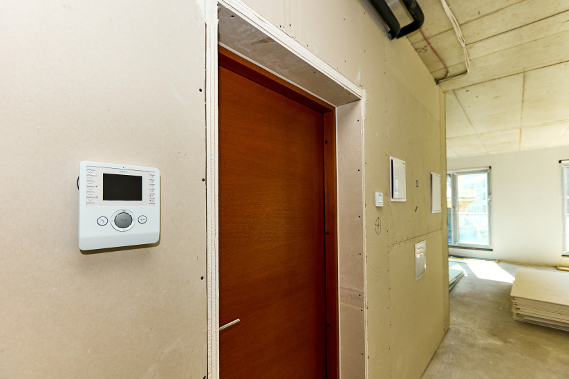 Wooden door with modern thermostat.