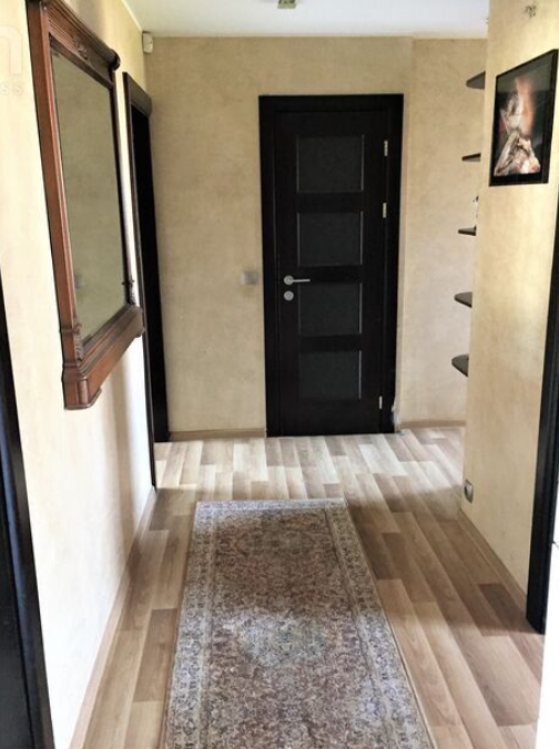 Corridor with dark doors and a carpet.