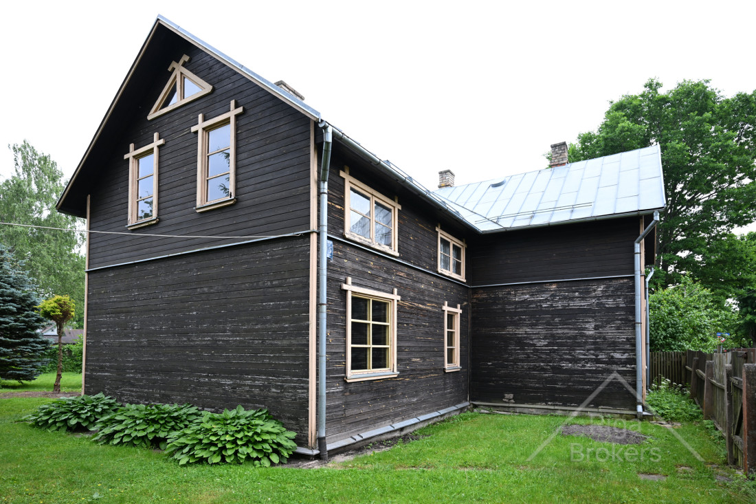 Māja ar dārzu un zaļu pagalmu.