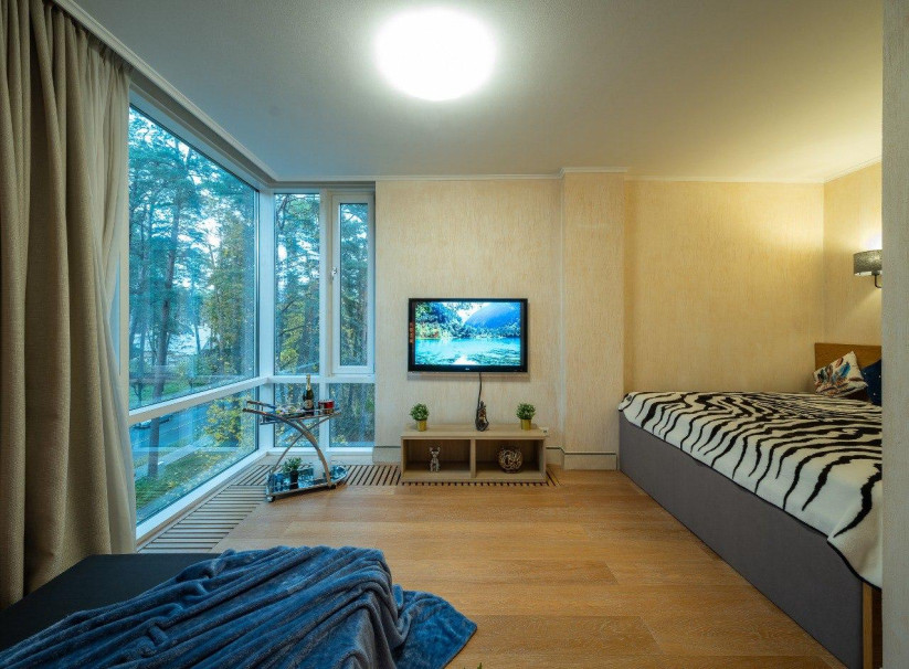 Bedroom with large windows and a bed.