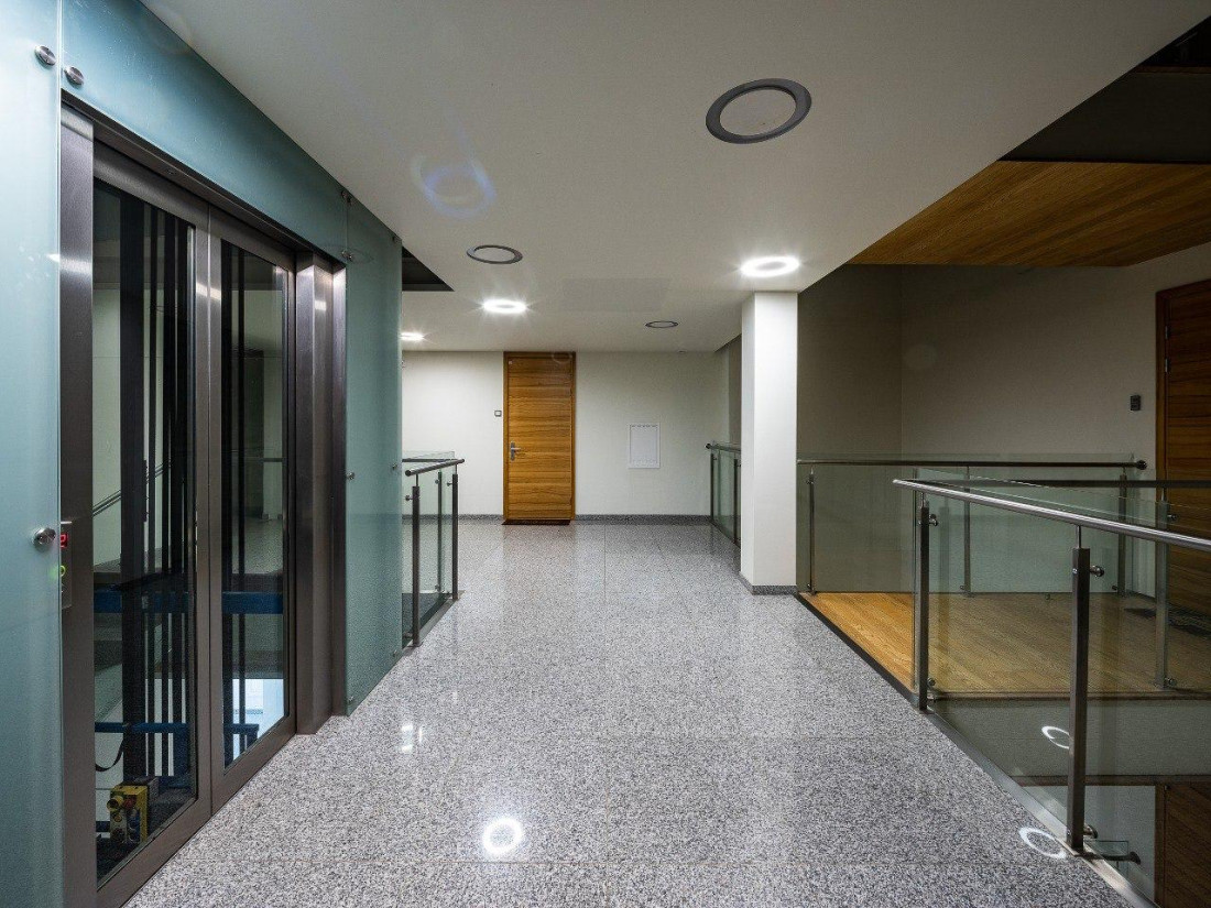 Modern building interior with elevator and glass railings.