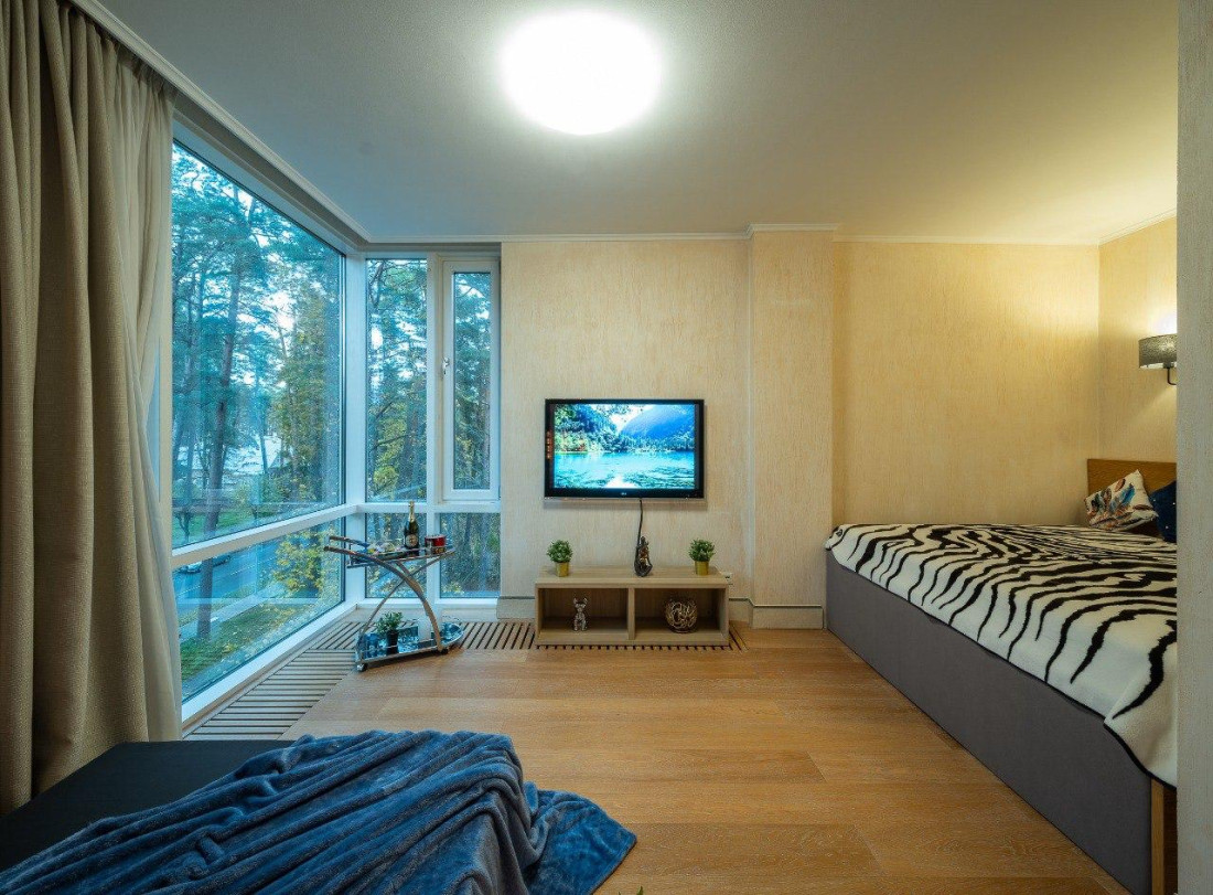 Bedroom with large windows and a bed.