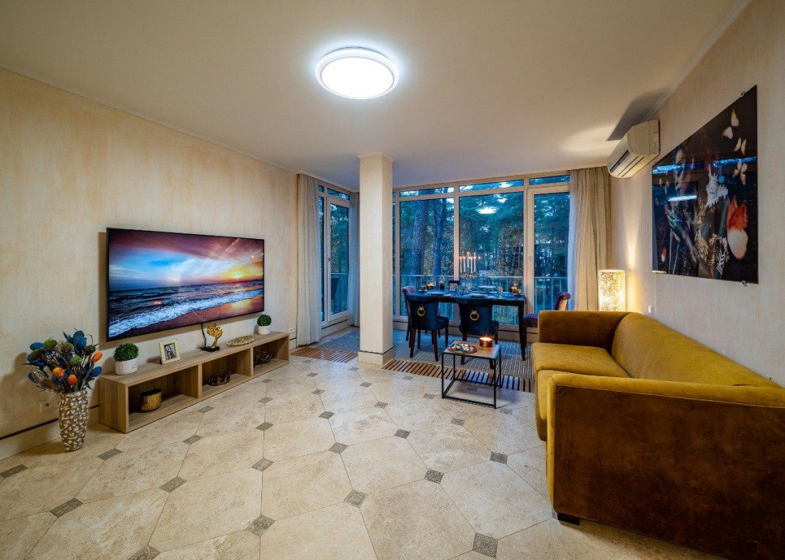 Living room with a large TV and table.