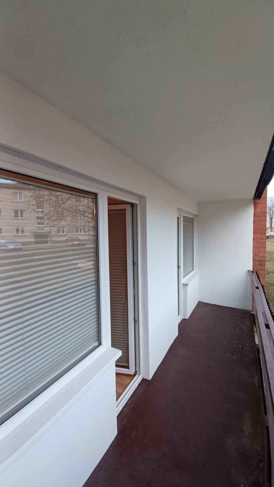 Balcony view with white walls and windows.