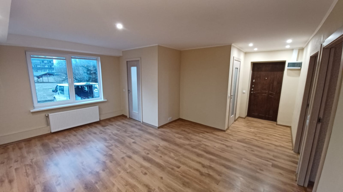 Spacious hallway with laminate flooring and doors.