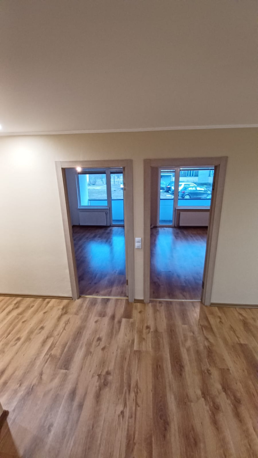 Two rooms with laminate flooring and doors.